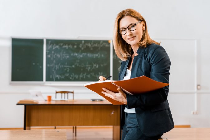 maestra con cuaderno de notas