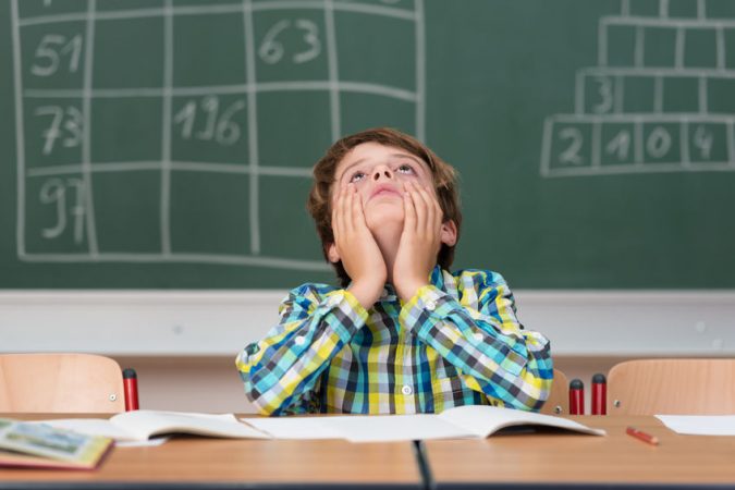 niño en la escuela aburrido