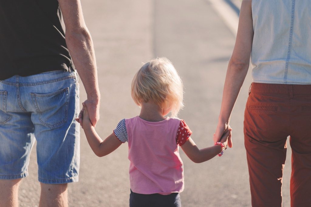 padres con niña de la mano