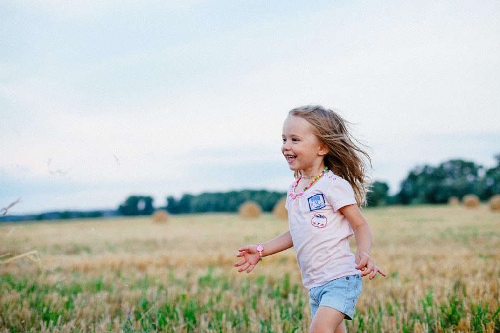 niña corriendo en el campo 