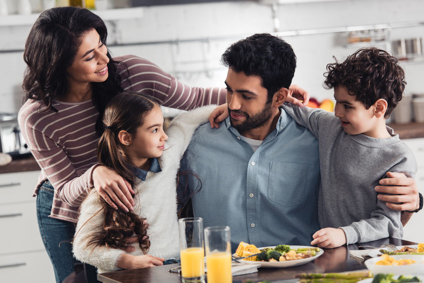 familia en mesa comiendo 