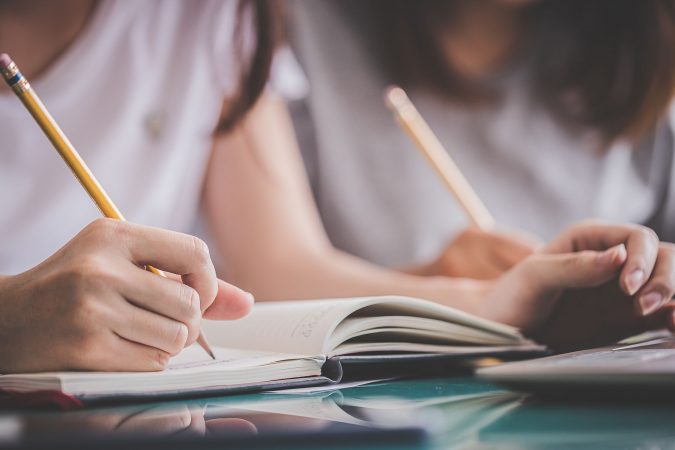 personas estudiando con lapiz en mano