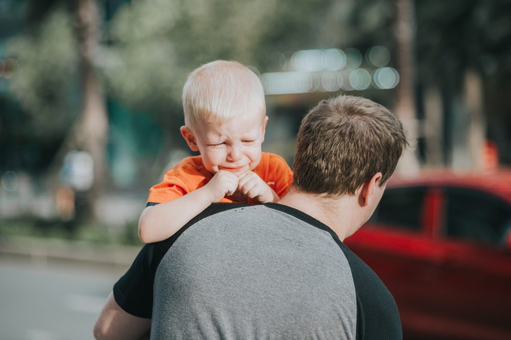 padre cargando con hijo